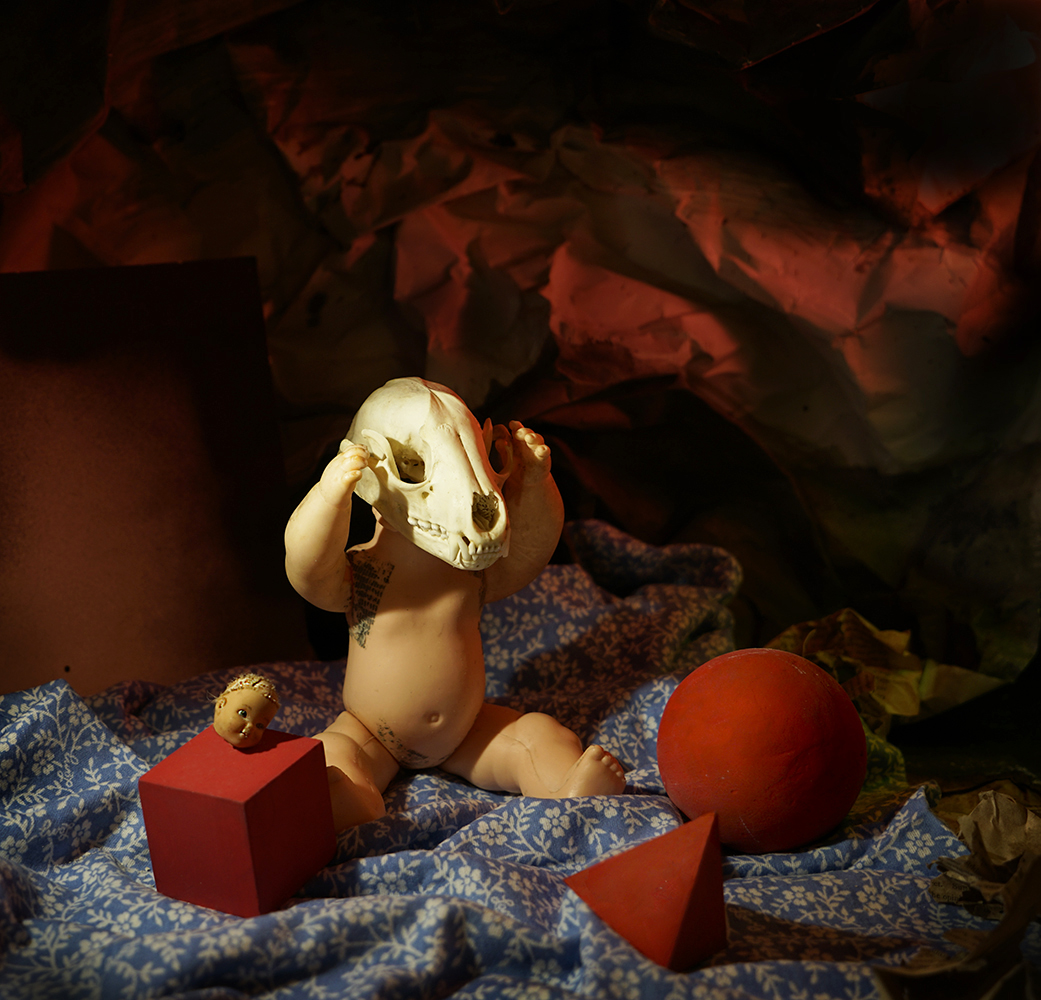 Surrealism, dream, nightmare, doll, skull, chimera, beheaded, baby, blanket, platonic solid, cube, pyramid, red, surreal baby, surreal doll